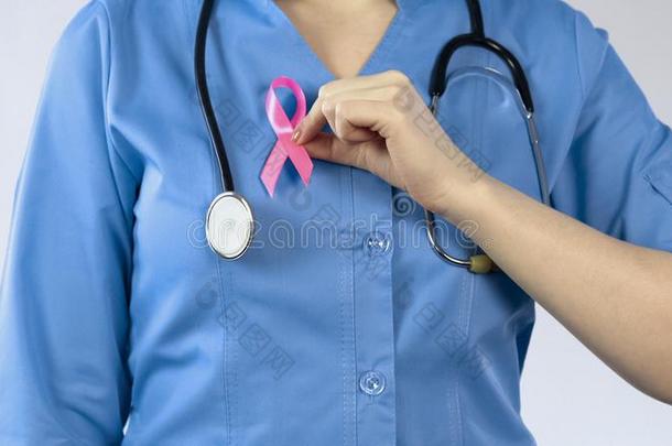 医生贴上粉红色的带制服,乳房抗癌的运动