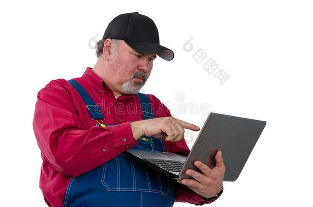 男人使人疲乏的粗布工作服起立和便携式电脑