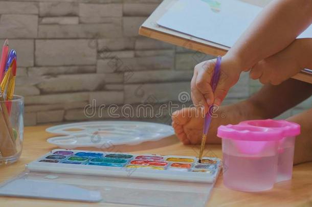 小孩女孩绘画在旁边水彩在家.