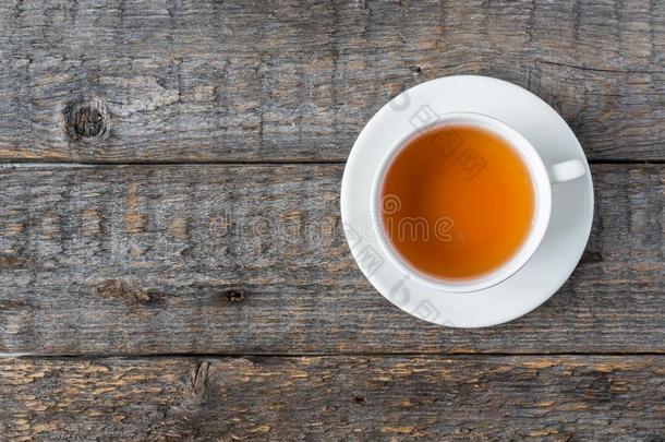 白色的茶水杯子和茶杯托向一乡村的木制的b一ckground复制品sp一c