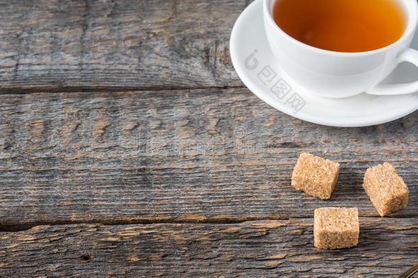 白色的茶水杯子和茶杯托棕色的手杖食糖向一乡村的木制的b一c