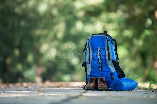 背包和鞋子背着背包徒步旅行的人休息向指已提到的人路在期间走徒步旅行.