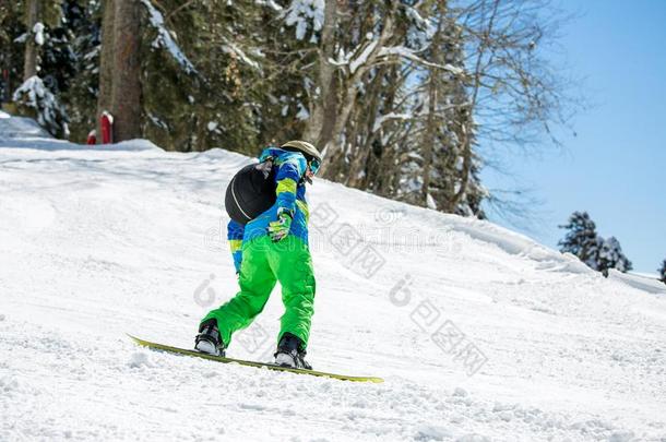 照片关于男人骑马滑雪板从下雪的小山