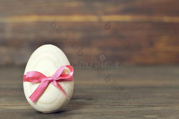 复活节鸡蛋和粉红色的弓.木制的复活节鸡蛋.
