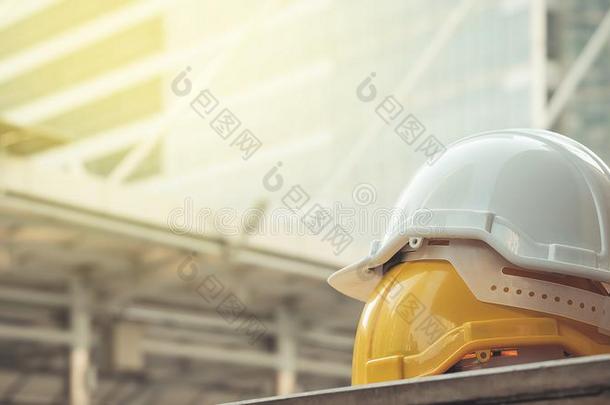 白色的,黄色的困难的安全头盔帽子为安全放映关于工作