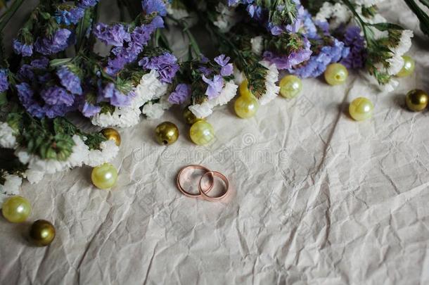 婚礼.婚礼戒指向牛皮纸布马乔夫和绿色的多叶的植物.
