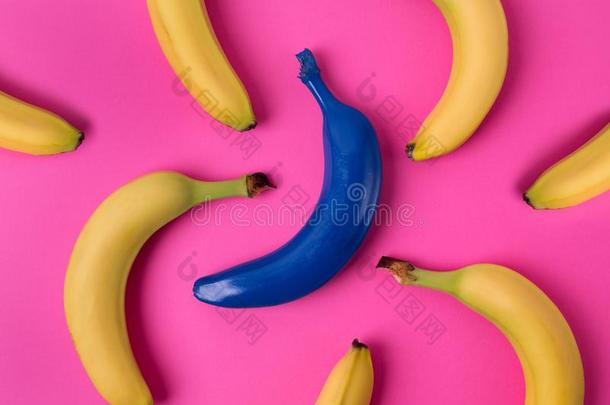 顶看法关于新鲜的黄色的和蓝色香蕉向粉红色的背景.
