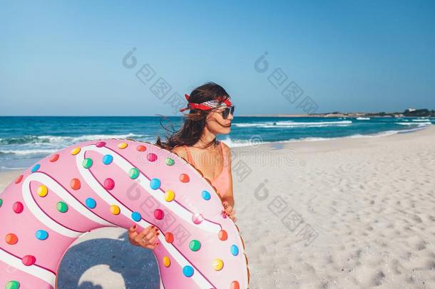 女孩和油炸圈饼充气垫向指已提到的人海滩
