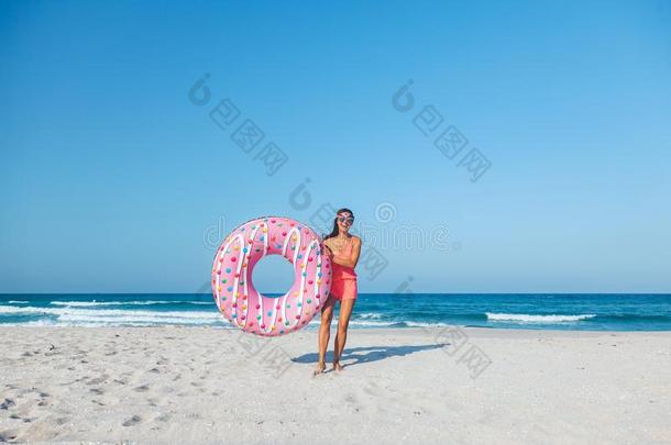 女孩和油炸圈饼充气垫向指已提到的人海滩