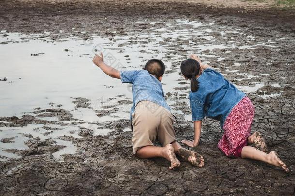孩子们和水向干旱的泥土采用热的.