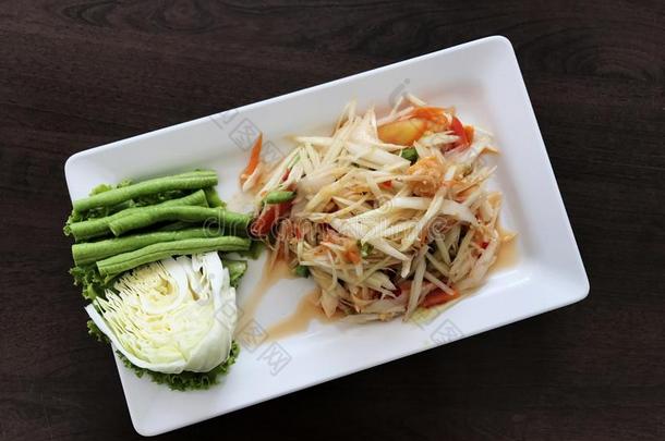 辛辣的番木瓜树沙拉和蔬菜向木制的表.ThaiAirwaysInternational泰航国际Traditi向