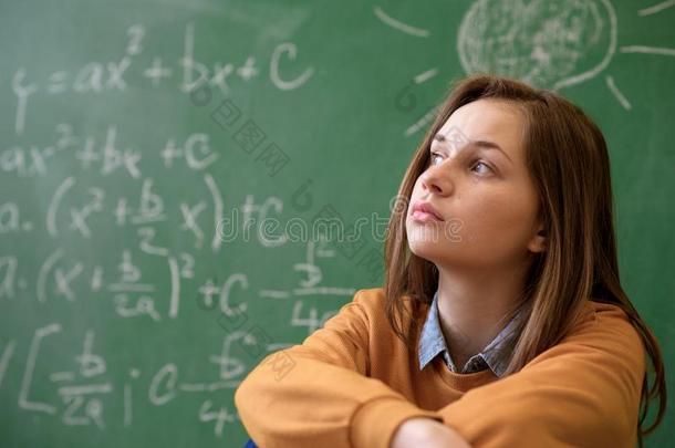 十几岁的青少年女孩采用数学班淹没在旁边指已提到的人数学公式.
