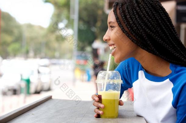 年幼的非洲的女人和把编成<strong>辫子</strong>头发小口喝果汁在咖啡馆