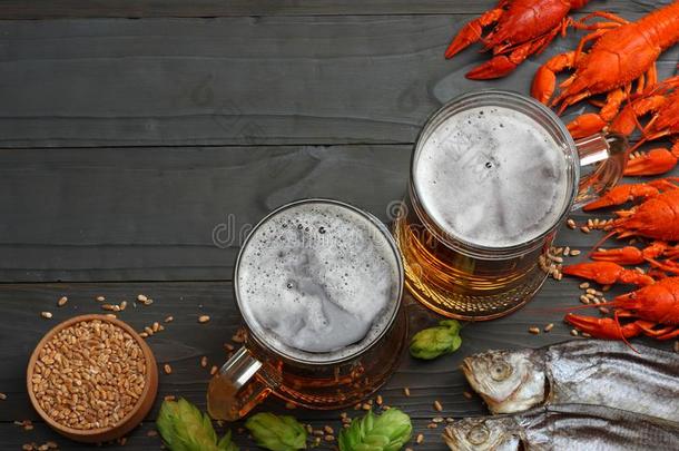玻璃啤酒和小龙虾,干燥的鱼和小麦耳向黑暗的木材