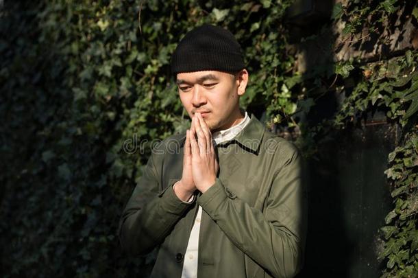 肖像关于亚洲人男人祈祷反对IVI穿衣的背景