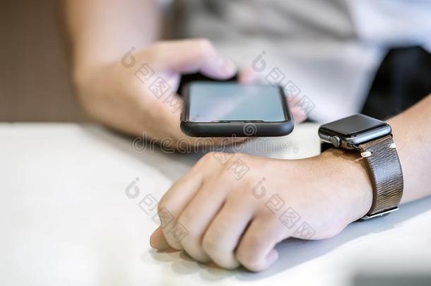 商人使用智能手机连接向智能手表在期间工作的