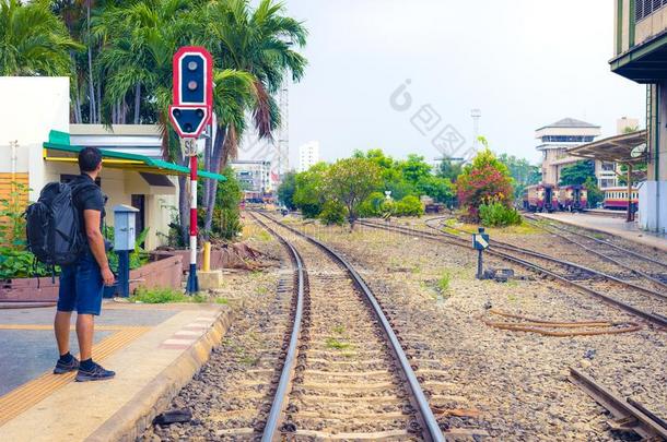 男人背着<strong>背包</strong>徒步旅行的人等候他的火车采用铁路车站采用一天.