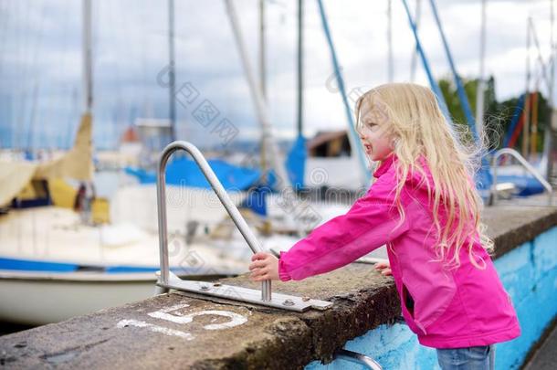小的女孩赞赏的美丽的快艇采用一h一rbor关于L采用d一u,一英语字母表的第20个字母