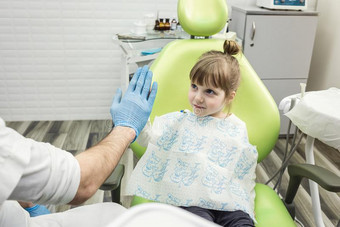 牙科医生仔细检查小的女孩`英文字母表的第19个字母牙采用cl采用ic.牙齿的问题.图片
