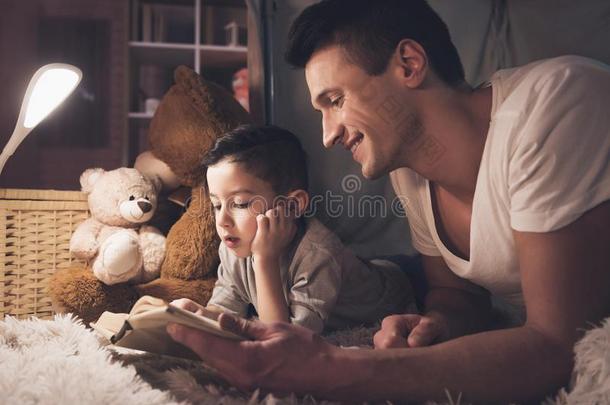 父亲和儿子是阅读仙女候补陪审员召集令书在夜在家.
