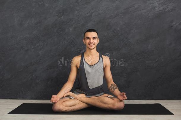 年幼的男人开业的瑜伽,轻松默想使摆姿势