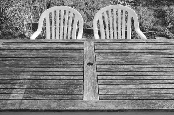 两个塑料制品椅子和一木制的t一ble采用指已提到的人veget一bleg一rden
