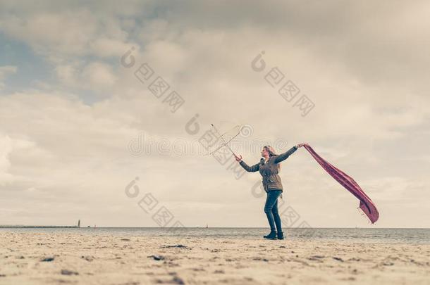 幸福的女人用于跳跃的和围巾向海滩