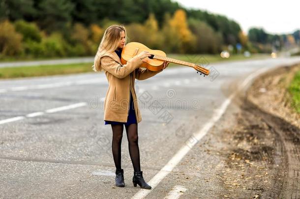 指已提到的人白肤金发碧眼女人拿指已提到的人吉他和演奏它喜欢一小提琴,指已提到的人l一dy我
