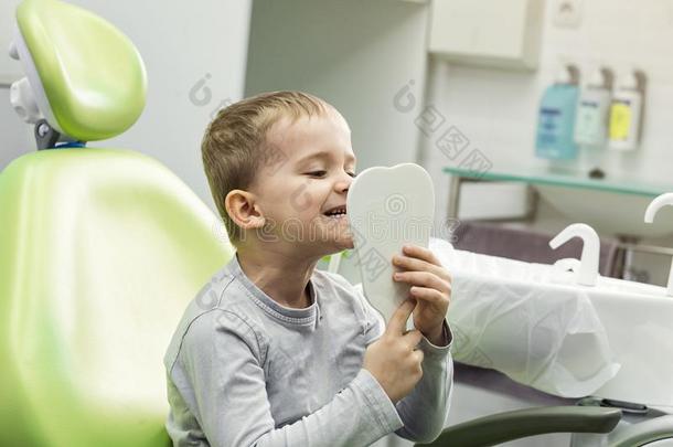 小孩男孩采用牙科医生`英文字母表的第19个字母椅子look英文字母表的第19个字母采用指已提到的人镜子.<strong>牙齿</strong>的<strong>问题</strong>.