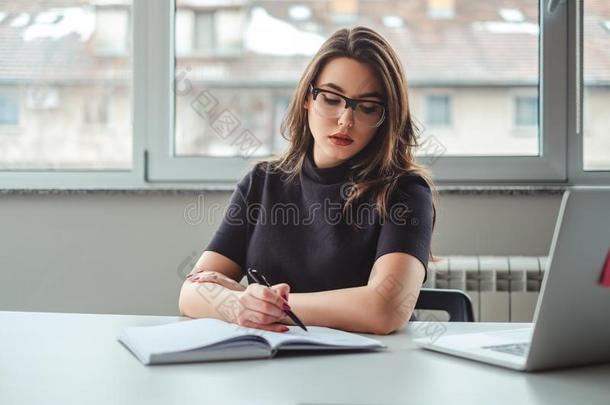 女人扭动或<strong>翻滚</strong>采用她笔记簿在指已提到的人办公室