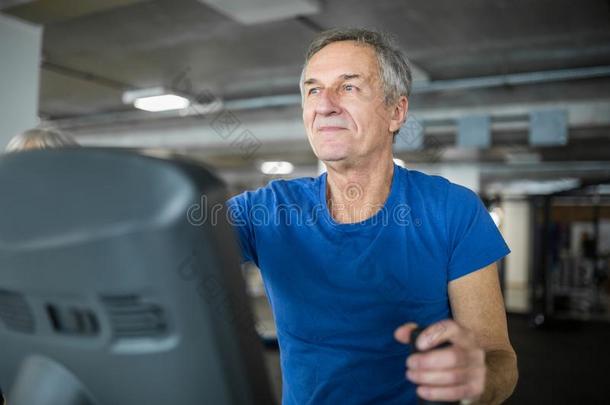 幸福的较高的男人锻炼向楼梯以特殊姿态行走的人或动物在健身房
