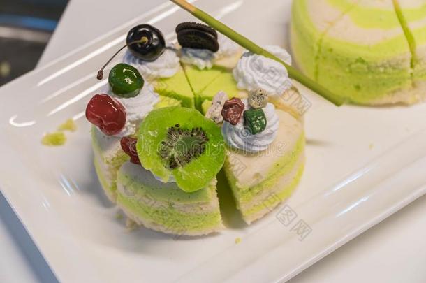 阿月浑子树蛋糕刨切的向白色的木制的背景