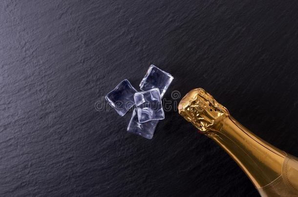 香槟酒瓶子和冰立方形的东西向黑的板岩盘子