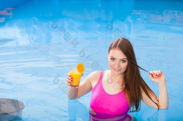 女孩和鸡尾酒喝令人轻松的在游泳水池