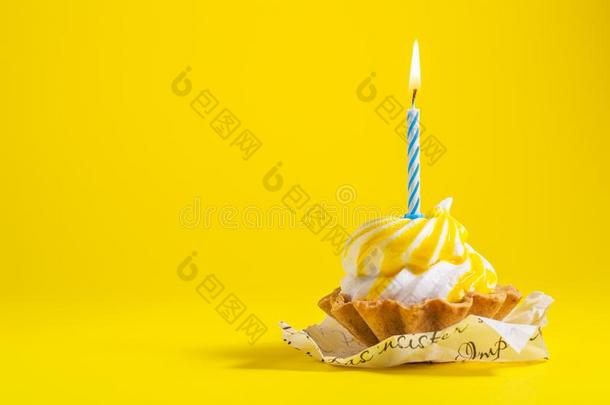美味的生日纸杯蛋糕和蜡烛向黄色的背景和警察