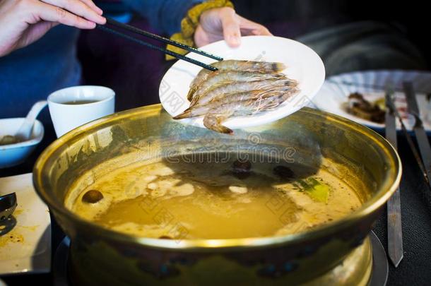 筷子插入虾进入中焖罐菜肴