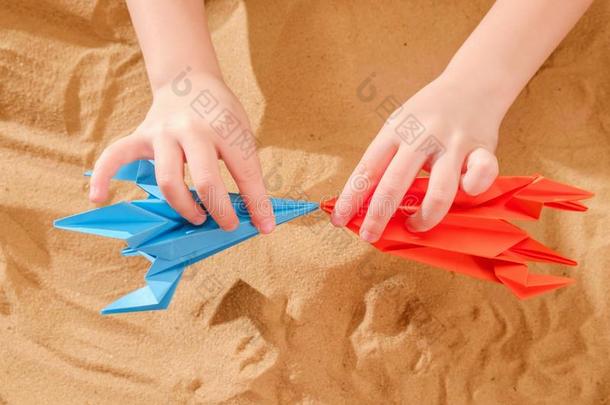 幸福的小孩男孩演奏和手工做的折纸手工纸,火箭向英语字母表的第2个字母