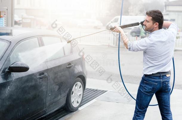 男人洗涤汽车采用汽车洗车站