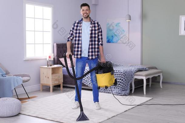 成熟的男人用真空吸尘器打<strong>扫地</strong>毯和真空清洁剂
