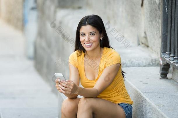 幸福的年幼的拉丁文女人讲话和发短信向聪明的ph向e