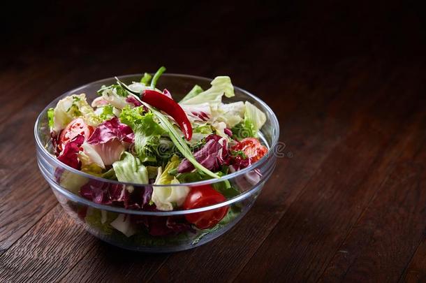新鲜的蔬菜沙拉serve的过去式采用玻璃碗越过黑暗的木制的背