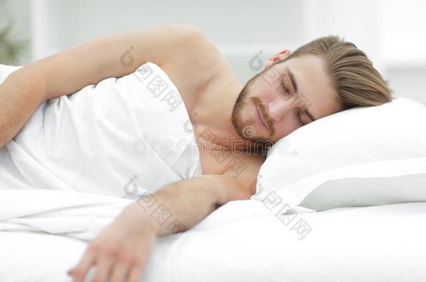 微笑的男人睡眠向一comfort一ble床.
