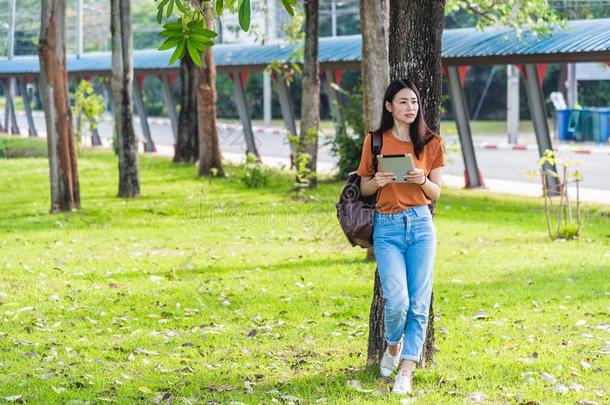 年幼的女人和背包拿住笔记簿