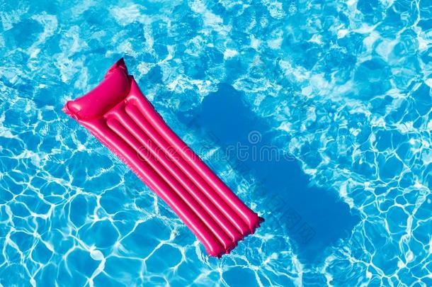 粉红色的需充气的床垫不固定的向水表面