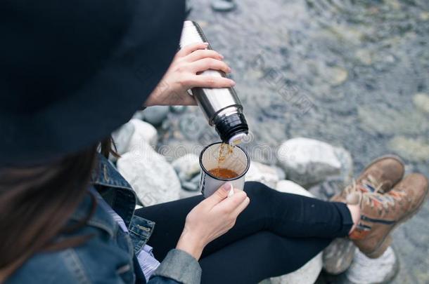 旅行支票女孩传布茶水从热水瓶杯子,在户外.年幼的沃玛