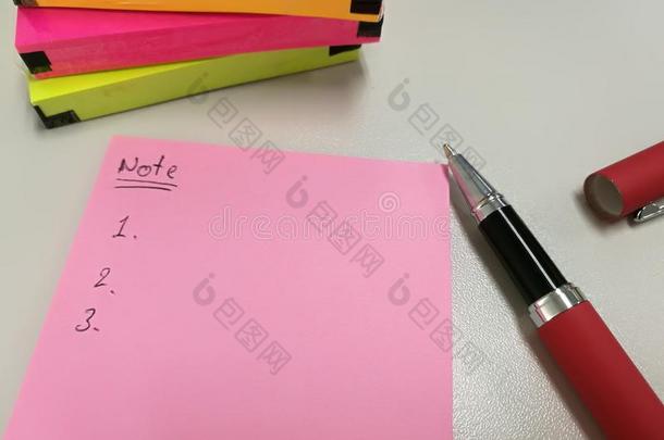 空白的粉红色的纸笔记.放在近处笔和一群关于富有色彩的纸no