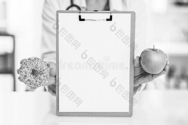 特写镜头向医学的医生女人展映空白的有纸夹的笔记板