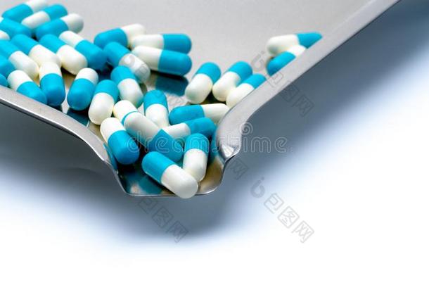 蓝色和白色的胶囊药丸和药物盘子向白色的背景