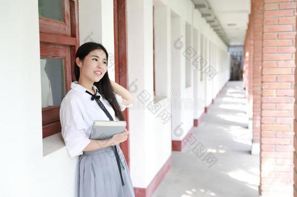 幸福的亚洲人<strong>中国</strong>人漂亮的女孩穿着学生一套外衣采用学校阅<strong>读</strong>