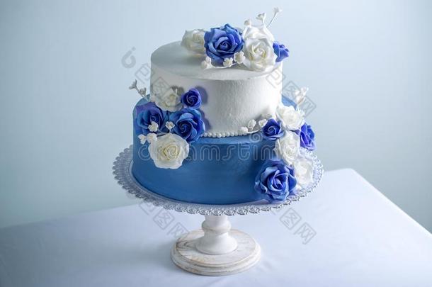 美丽的两个层层排列白色的和蓝色婚礼蛋糕装饰和
